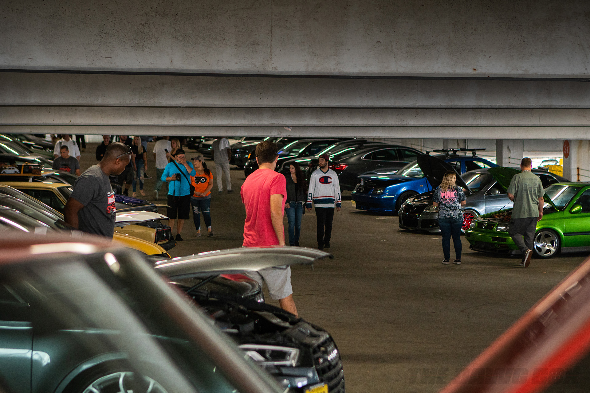 Cars lined up and displaying their engines in a parking garage