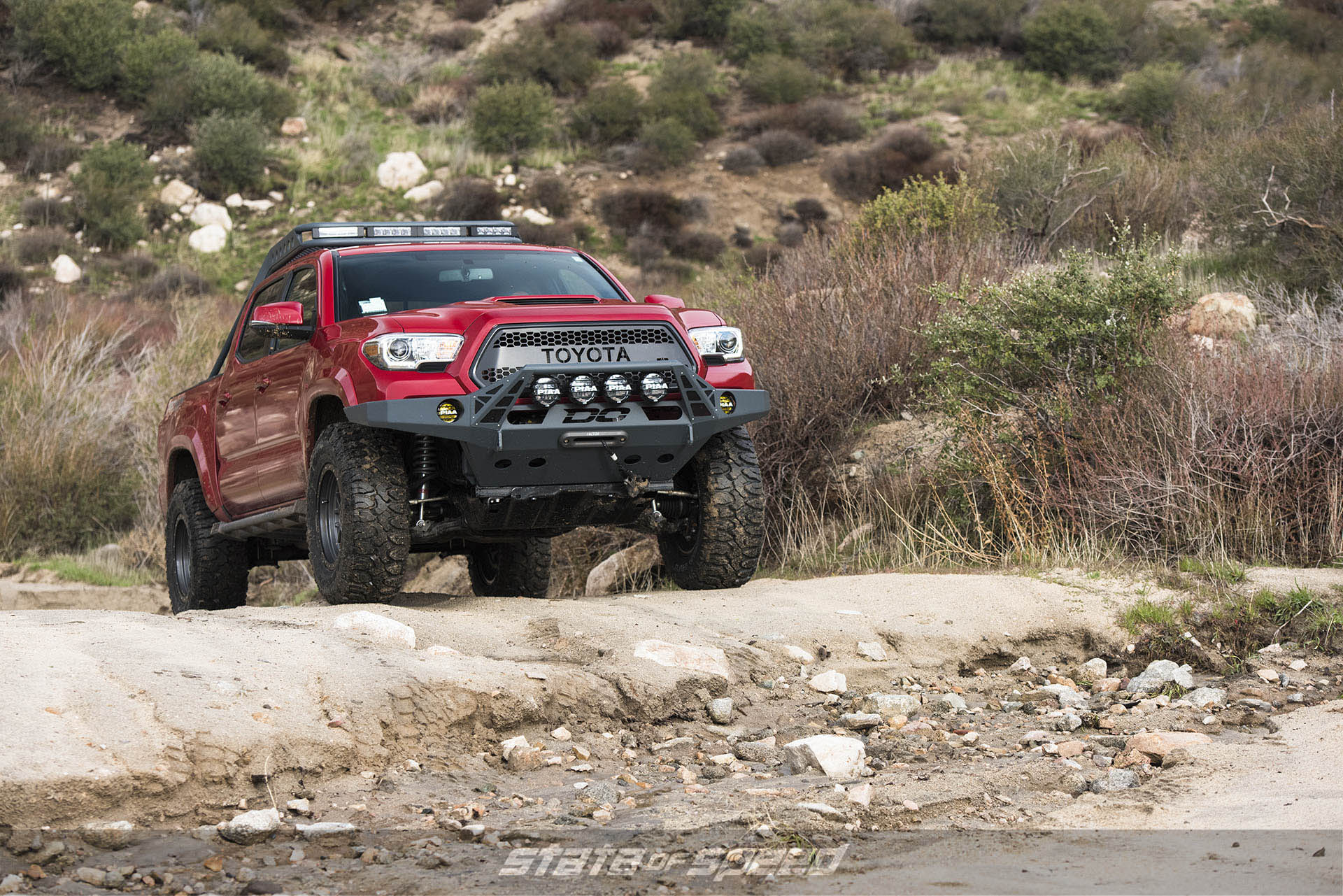 Modified Red Toyota Tacoma with Milestar Patagonia M/Ts