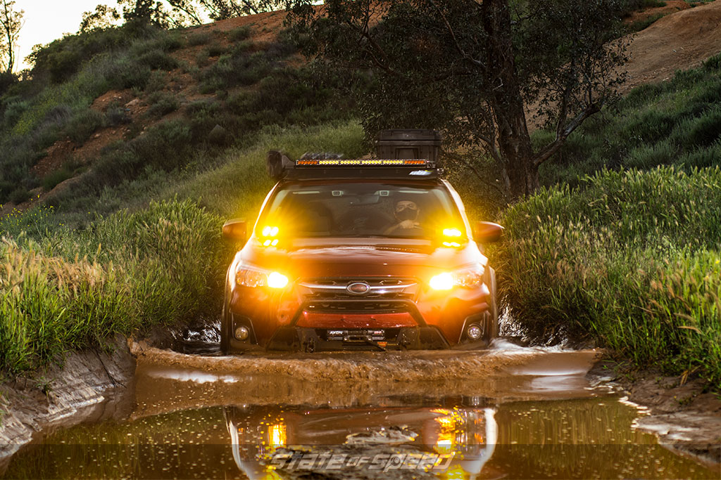 Red Subaru Crosstrek going through the mud