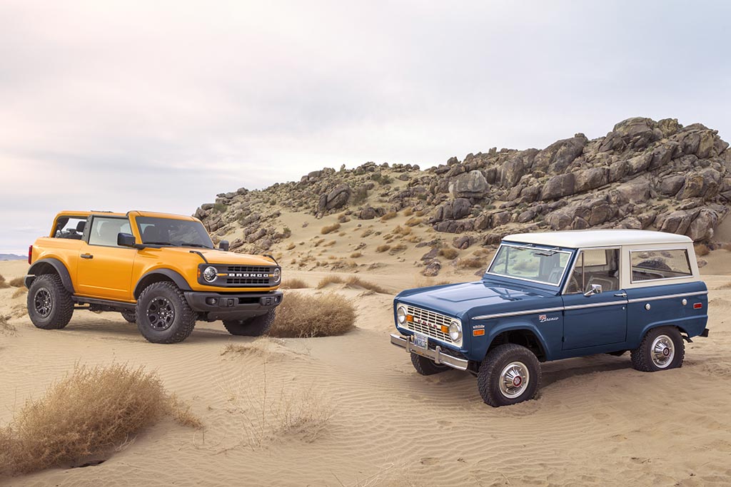 Pre-production 2021 Bronco two-door SUV takes its rugged off-road design cues from the first-generation Bronco, the iconic 4x4 that inspired generations of fans. yellow 2021 ford bronco next to a blue first generation ford bronco in a sandy desert