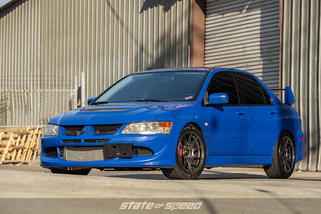 Blue Mitsubishi Evo near a warehouse