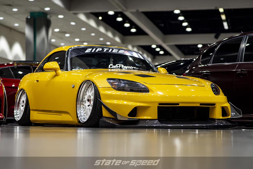 slammed and bagged Yellow Honda S2000 with an air suspension system at a car show